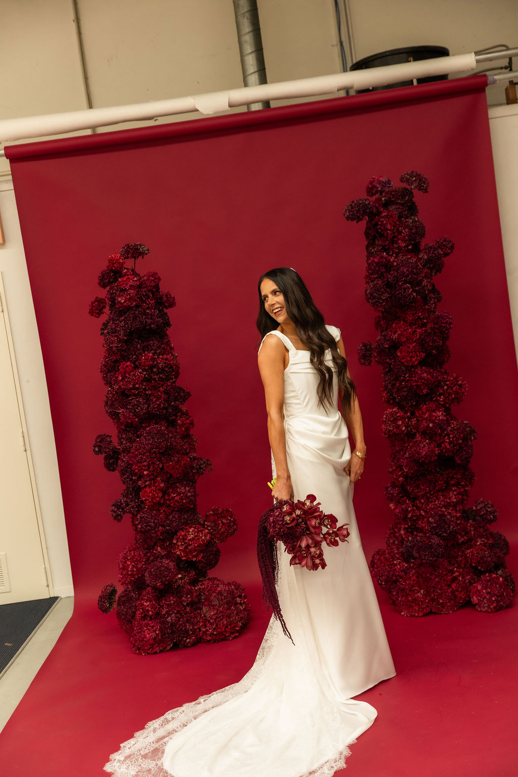 Behind the scenes of the FOUNDATION editorial — the red paper backdrop and dried floral arches in the new Sarah Stoute Bespoke studio photography space