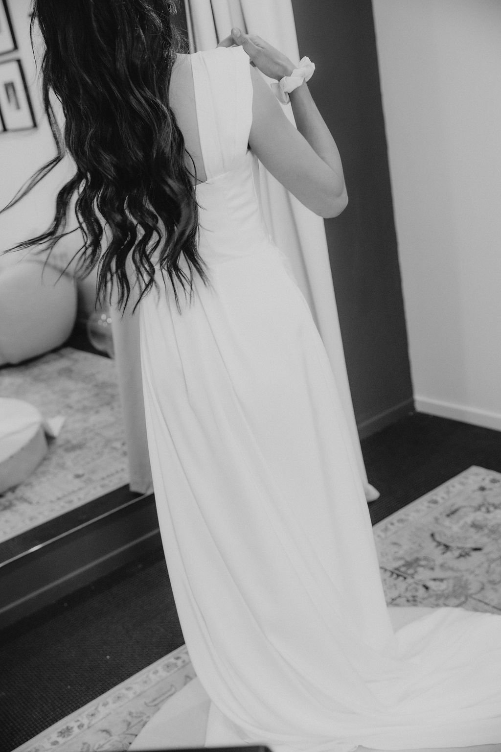 Bride stepping into her gown in the fitting room mirror at the Sarah Stoute Bespoke studio, Christchurch