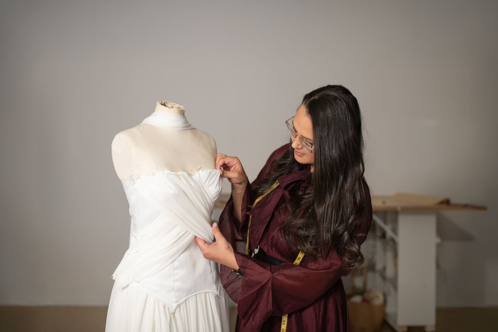 Sarah Stoute fitting a wedding dress on a mannequin in the Christchurch studio
